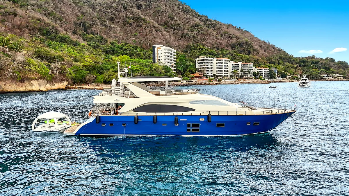 Side profile of MÍO yacht beside the coast